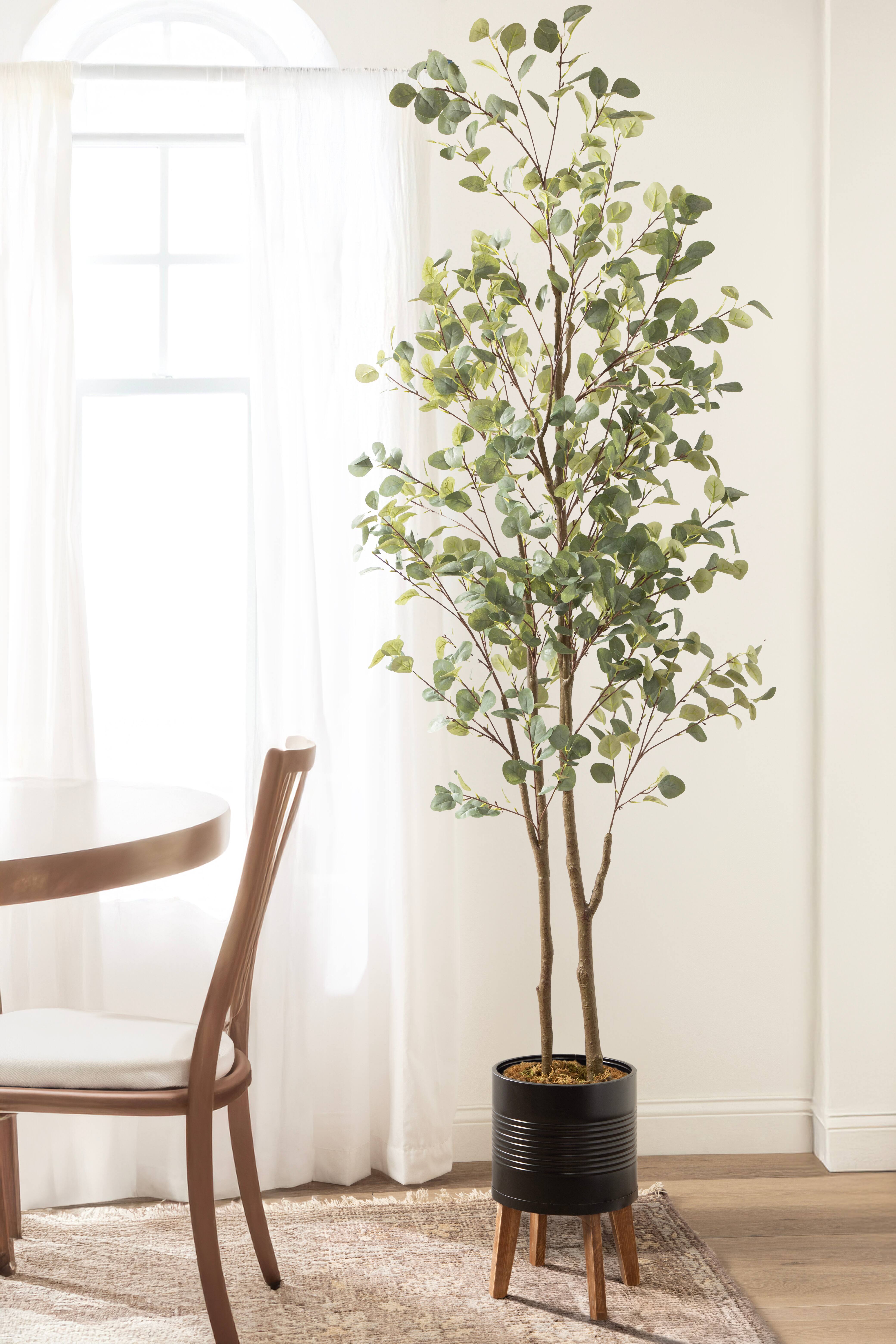 Kate and Laurel 8ft. Eudora Faux Eucalyptus Tree in Rustic Brown Footed Planter