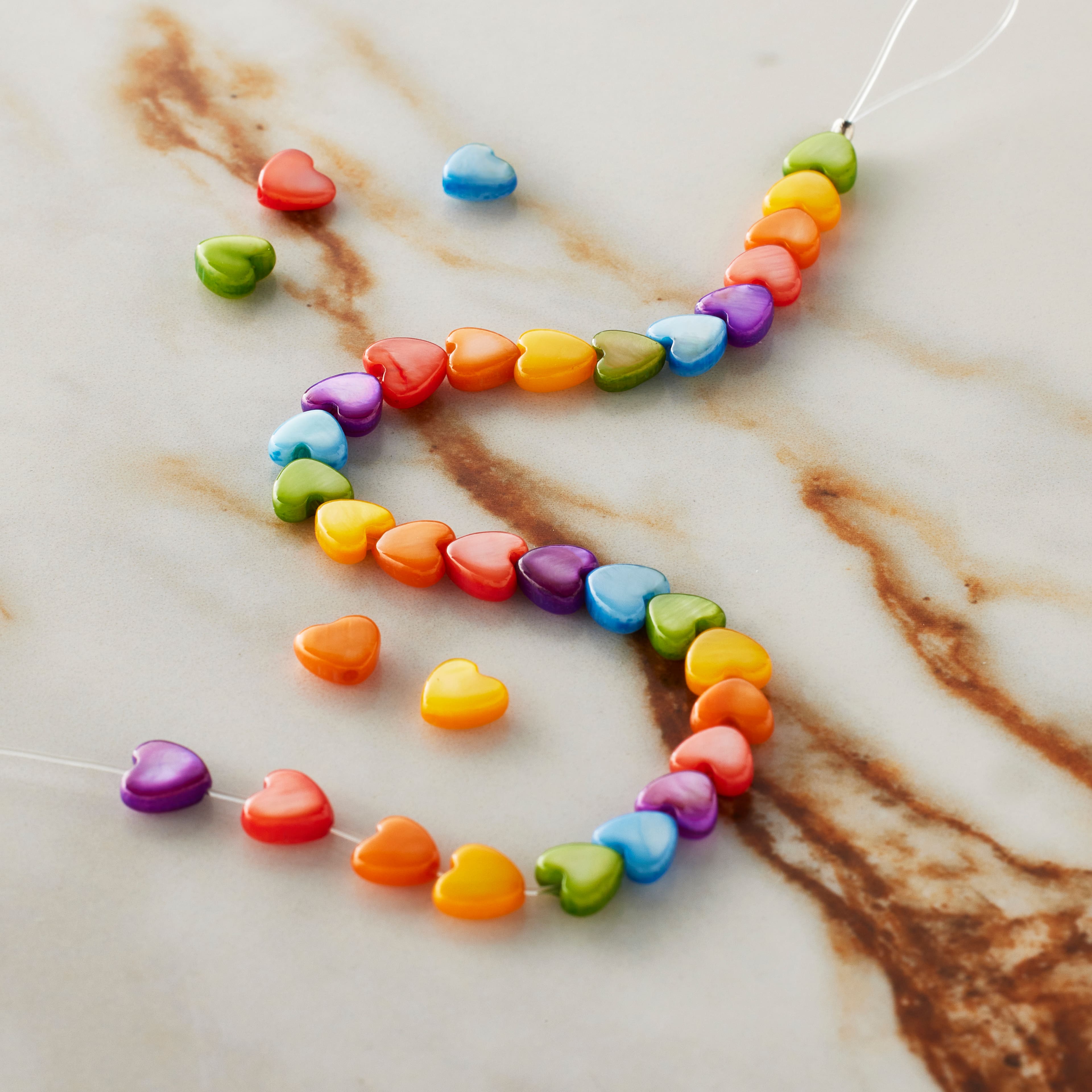 12 Packs: 28 ct. (336 total) Dyed Shell Heart Beads by Bead Landing™