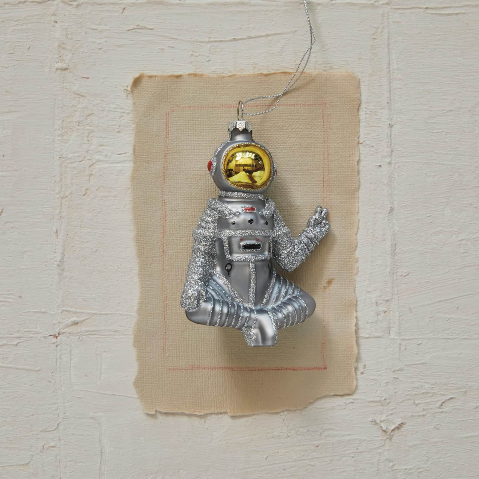 Hello Honey® 4.75" Silver & Gold Finish Glass Sitting Astronaut Ornament with Peace Sign & Glitter Design