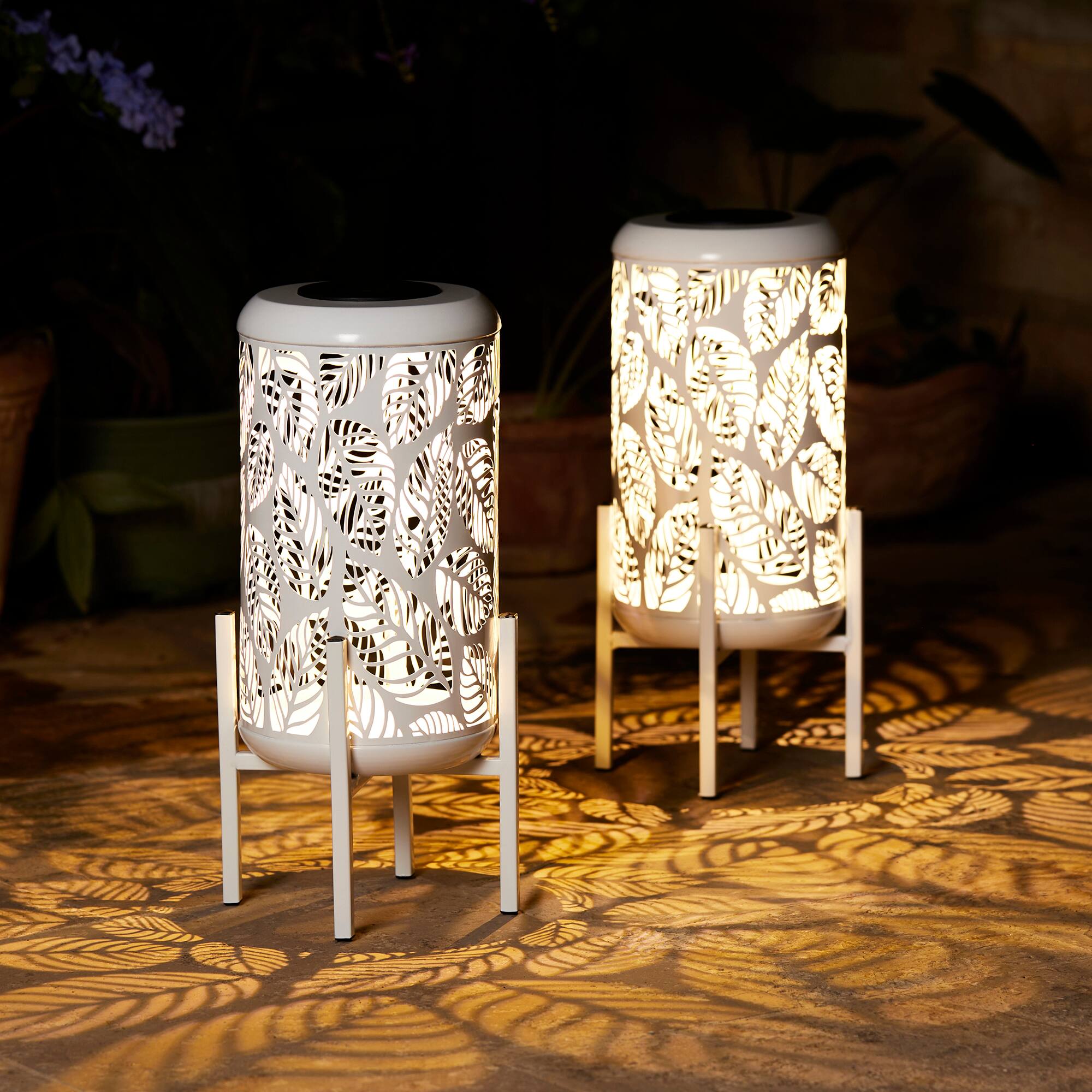 Glitzhome&#xAE; 14.25&#x22; White Metal Cutout Leaves Pattern Solar Powered LED Outdoor Lanterns, 2ct.