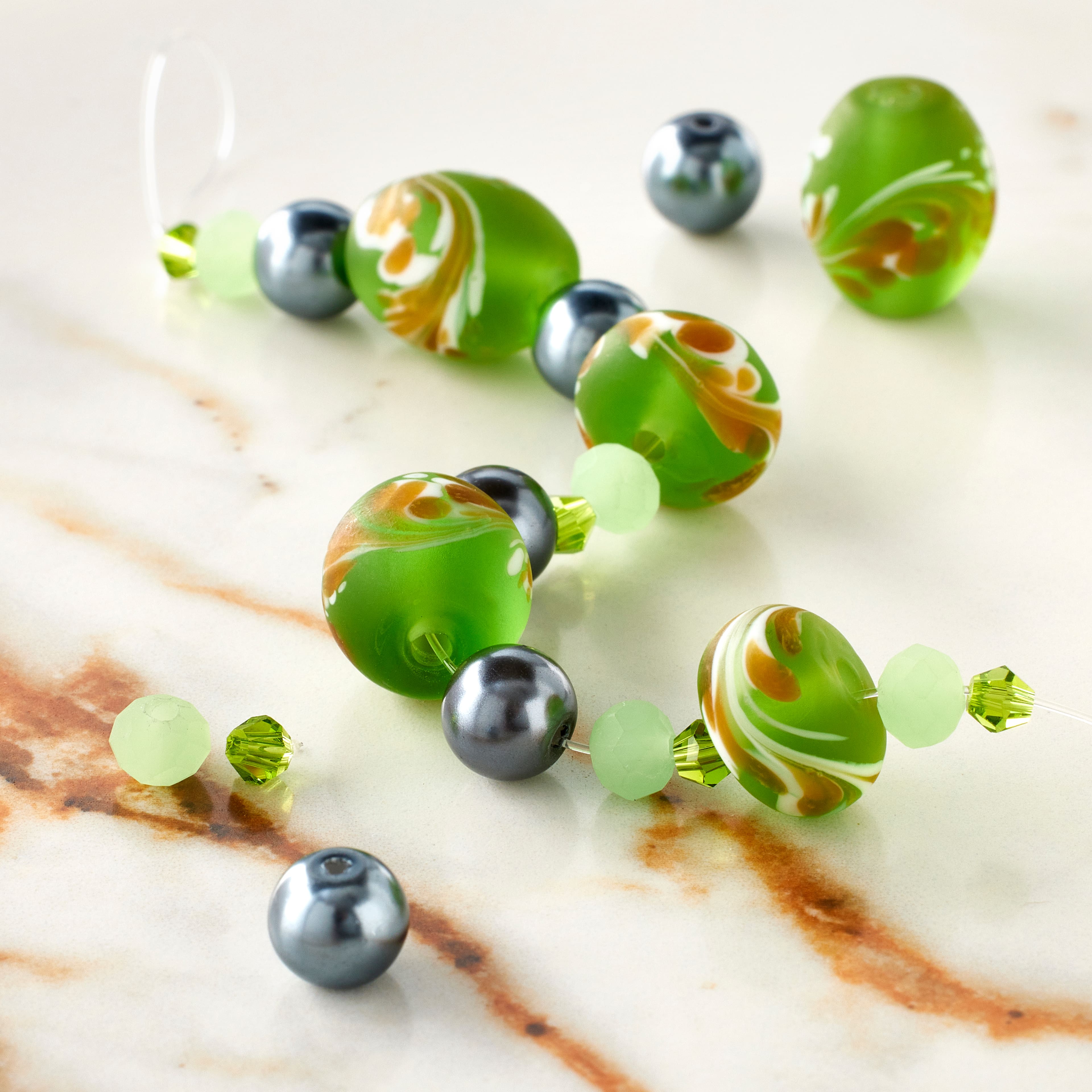 12 Pack: Green Lampwork Glass Swirl Rondelle & Oval Beads by Bead Landing™