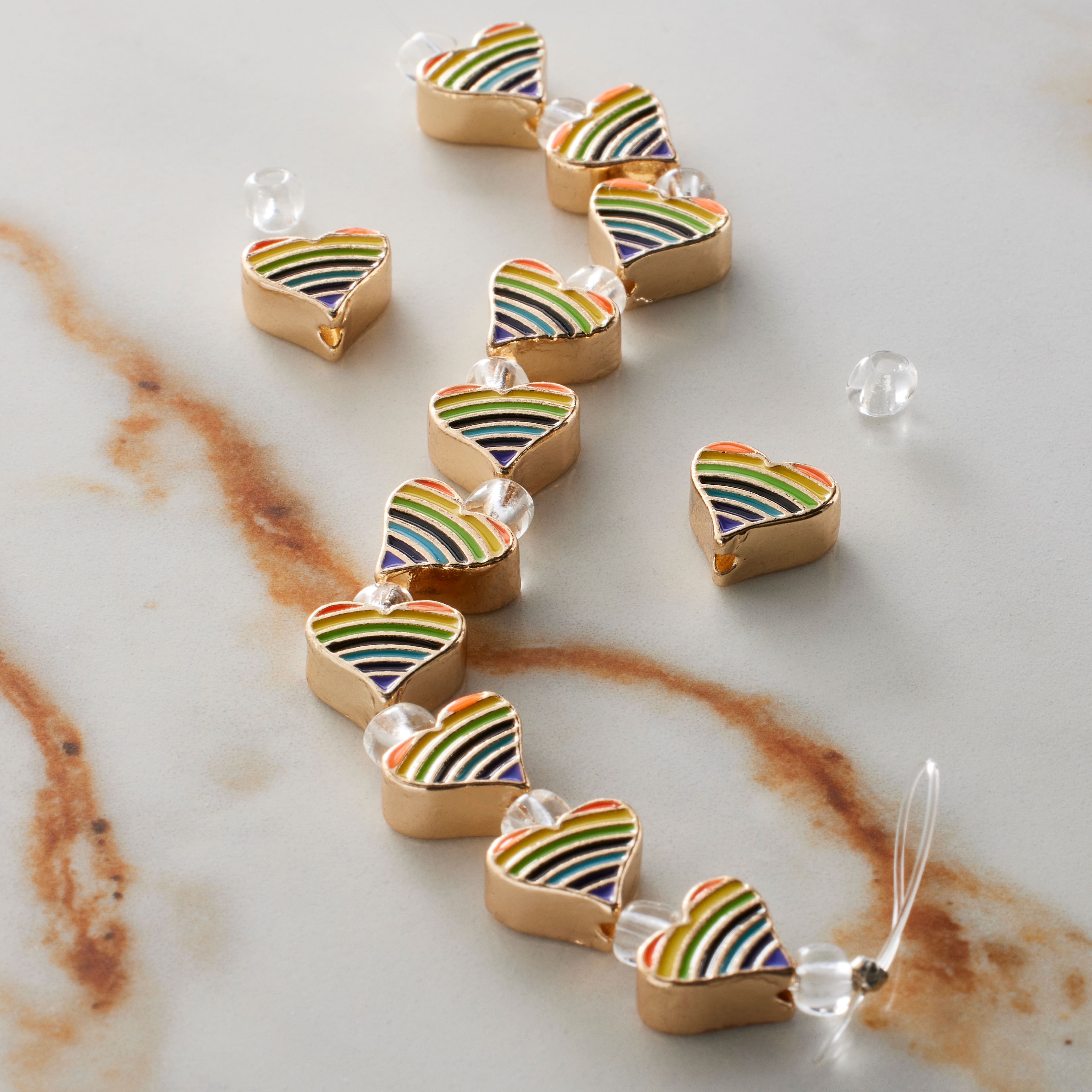 6 Packs: 12 ct. (72 total) Rainbow Stripe & Gold Heart Beads, 9mm by Bead Landing™