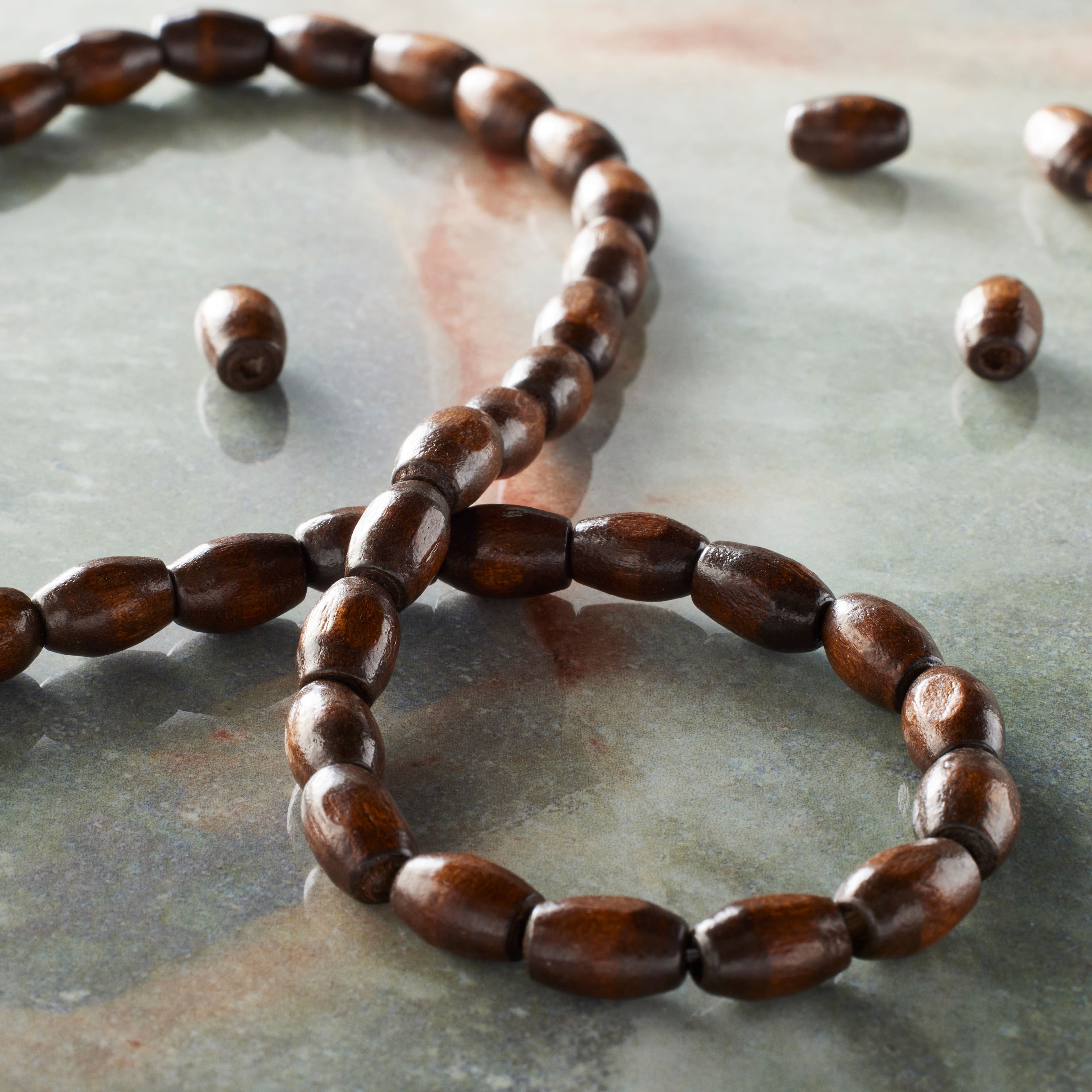 12 Packs: 54 ct. (648 total) Brown Wood Oval Beads by Bead Landing®