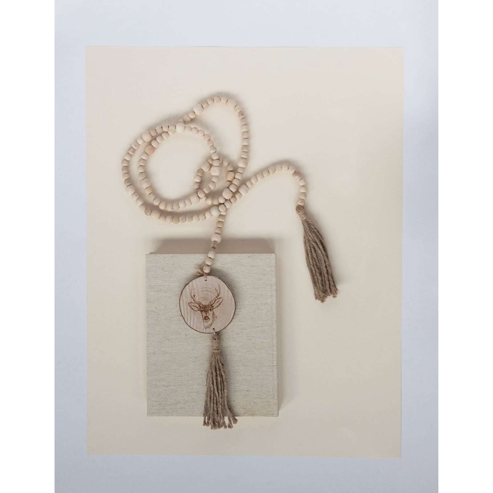Hello Honey® 6ft. Paulownia Wood Beads with Deer Icons & Tassels Garland