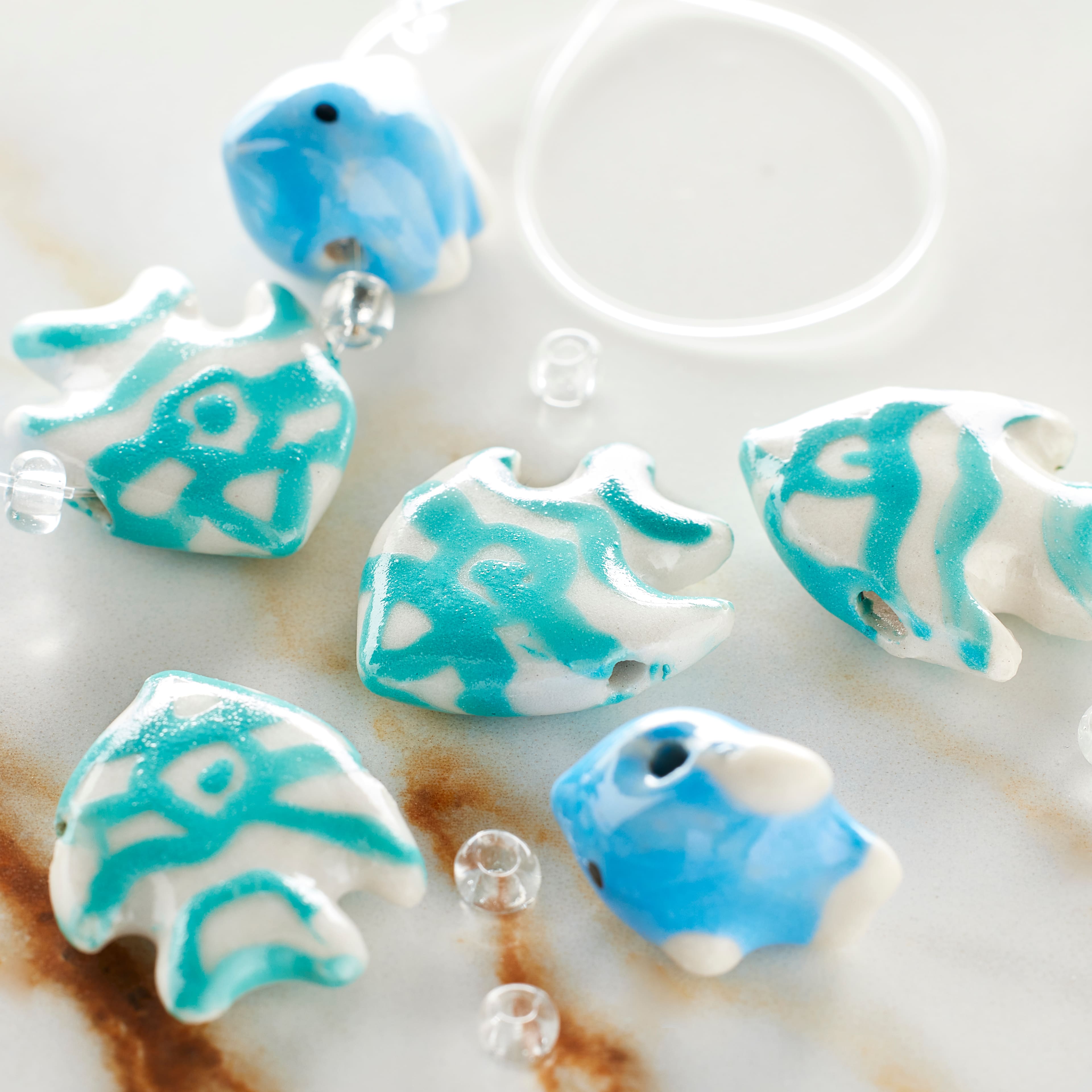 12 Packs: 8 ct. (96 total) Blue Fish Mix Ceramic Beads by Bead Landing™