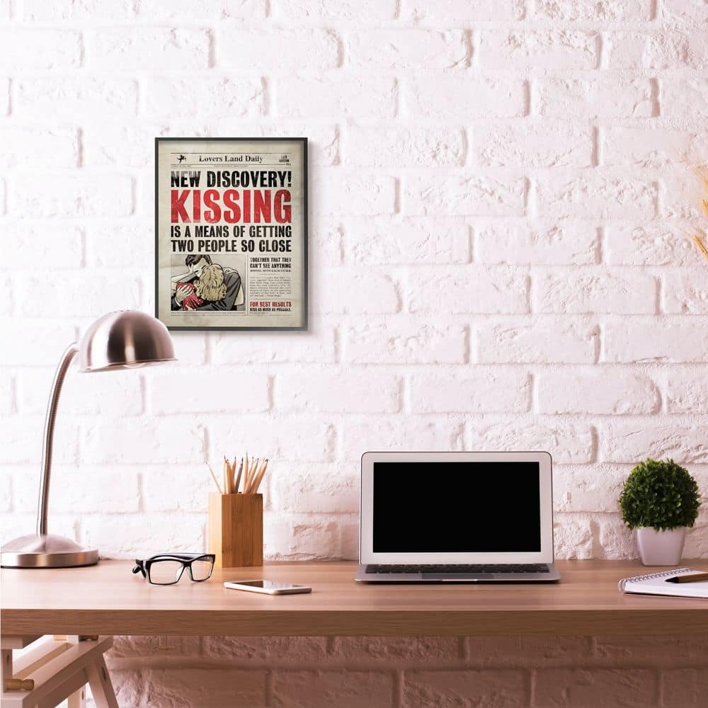 Stupell Industries Kissing Newspaper Wall Art in Black Frame